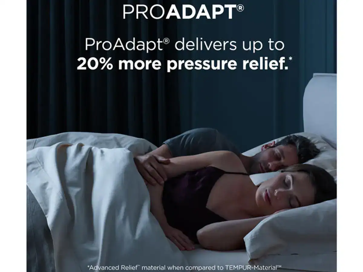 A couple sleeping comfortably on a Tempur-Pedic TEMPUR-ProAdapt® 12" Soft Mattress, a woman in a purple top with text above stating "TEMPUR-ProAdapt delivers up to 20% more pressure relief.