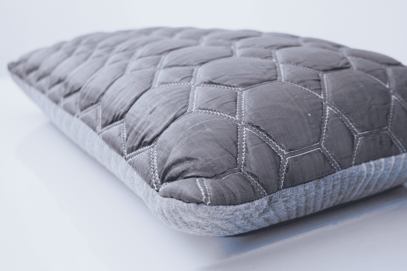 Gray quilted throw pillow on white background.