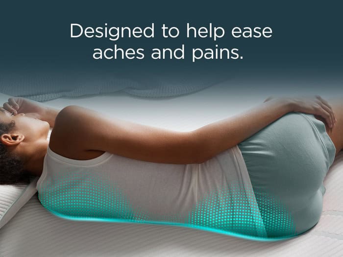 A person lying on their side on a mattress with highlighted dotted patterns around their lower back and hips. Text above reads, "Designed to help ease aches and pains with the Tempur-Pedic TEMPUR-LuxeAdapt® 13" Medium Hybrid Mattress.