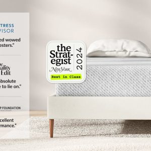 A minimalist bedroom features a neatly made bed with a white Original Hybrid Mattress and light grey quilted cover. Accolades from Mattress Advisor, The Quality Edit, and Sleep Foundation are displayed, highlighting praise for the bed's comfort and performance.