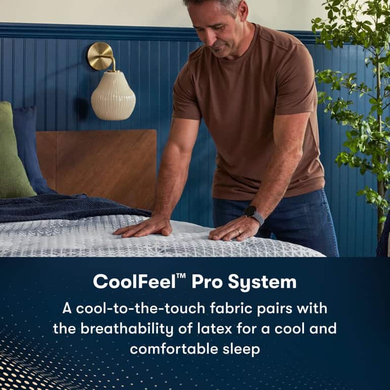 A person in a brown shirt is pressing down on a mattress with their hand. The text at the bottom reads "CoolFeel™ Pro System: A cool-to-the-touch fabric pairs with the breathability of latex for a cool and comfortable sleep." A nightstand with a lamp and bed, featuring the Serta iComfortPro Mattress: Kingston Firm, are in the background.