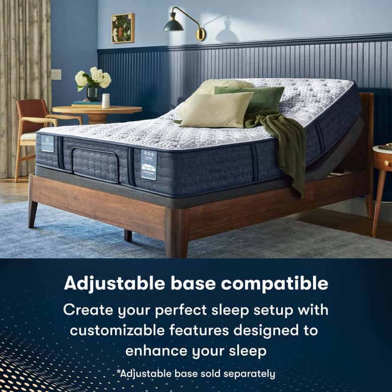 A modern bedroom with a dark blue and wood theme features a double bed with a Serta iComfortPro Mattress: Ambrose Plush on an adjustable base, partly elevated. Text reads: "Adjustable base compatible. Create your perfect sleep setup with customizable features designed to enhance your sleep." (*Adjustable base sold separately).