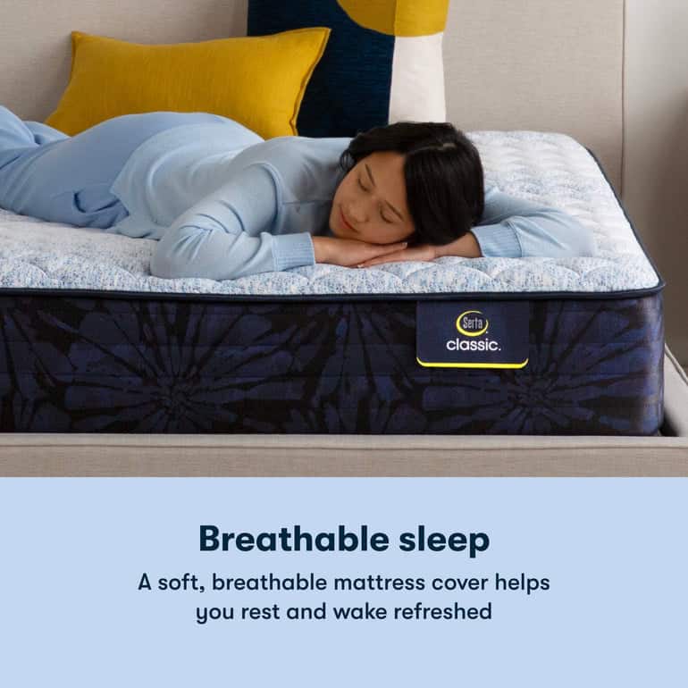 A person is sleeping on their stomach on a Serta Classic Mattress with a blue floral pattern. They are dressed in light blue pajamas, and there is a blue and yellow pillow in the background. Text below the image reads: "Breathable sleep: A soft, breathable mattress cover helps you rest and wake refreshed.