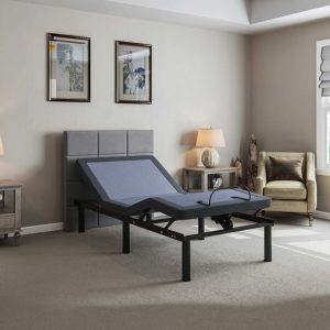 A modern bedroom features the adjustable Bed Tech 2000 Base with a gray headboard, surrounded by minimalist decor: nightstands with lamps, framed artwork on the wall, and a comfy chair by the window. The design is contemporary and elegantly simple.