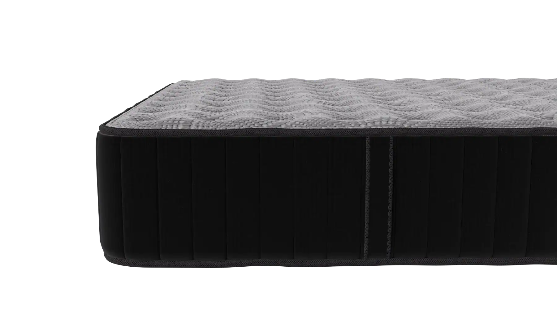 A close-up view of the corner of a mattress with a textured, light gray top and black sides, showing its thick and cushioned construction.