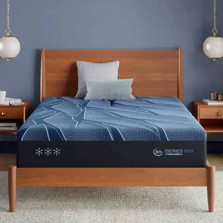 A modern wooden bed features a blue and black Serta iSeries NXG 3500 Hybrid — Medium mattress, two accent pillows, and matching nightstands with lamps, all set against a blue wall.