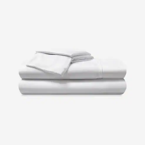 A neatly folded stack of Hyper - Cotton Performance Sheets, including a fitted sheet, flat sheet, and pillowcases, is placed against a plain white background.