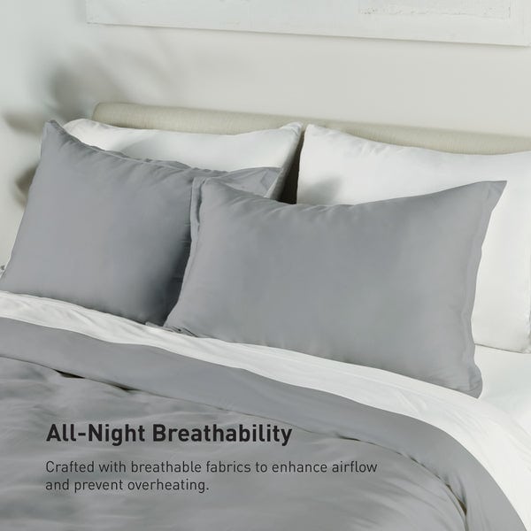 A neatly made bed features the Performance Duvet & Sham Set - Solid in gray atop white sheets. Text reads: "All-Night Breathability. Crafted with performance duvet fabrics to enhance airflow and prevent overheating.