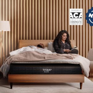 A woman reads in bed while a man sleeps beside her on a Brooklyn Titan Plus Luxe (Copy) mattress. The modern bedroom has wood paneling, a floor lamp, and ACA endorsement and "NEW" badges are visible in the top right corner.