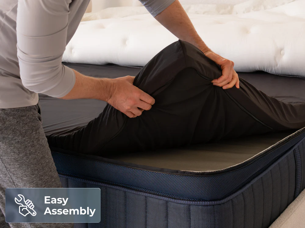 Someone folding a ThermoBalance Elite pillow in black on a mattress.